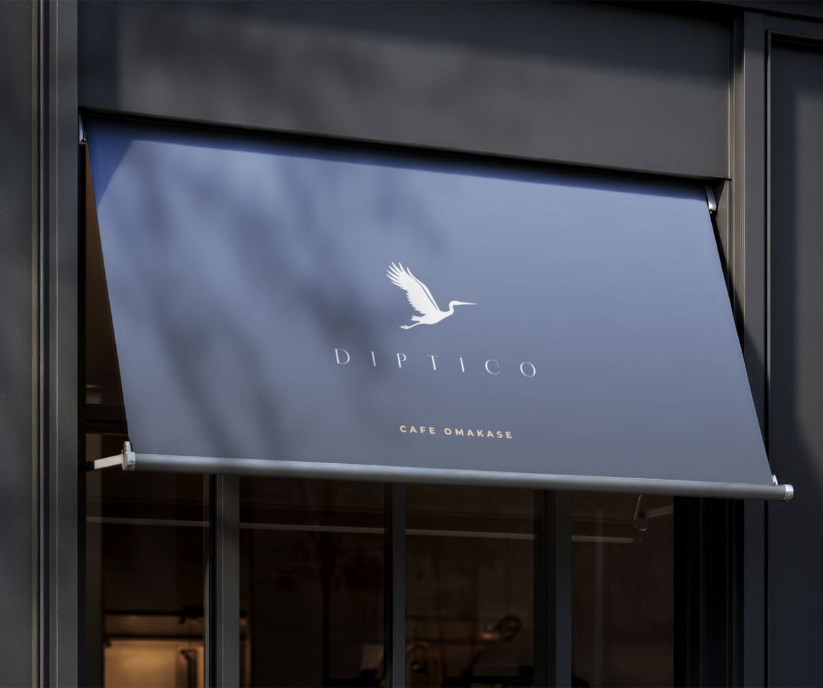Diptico awning with a white crane over the café entrance