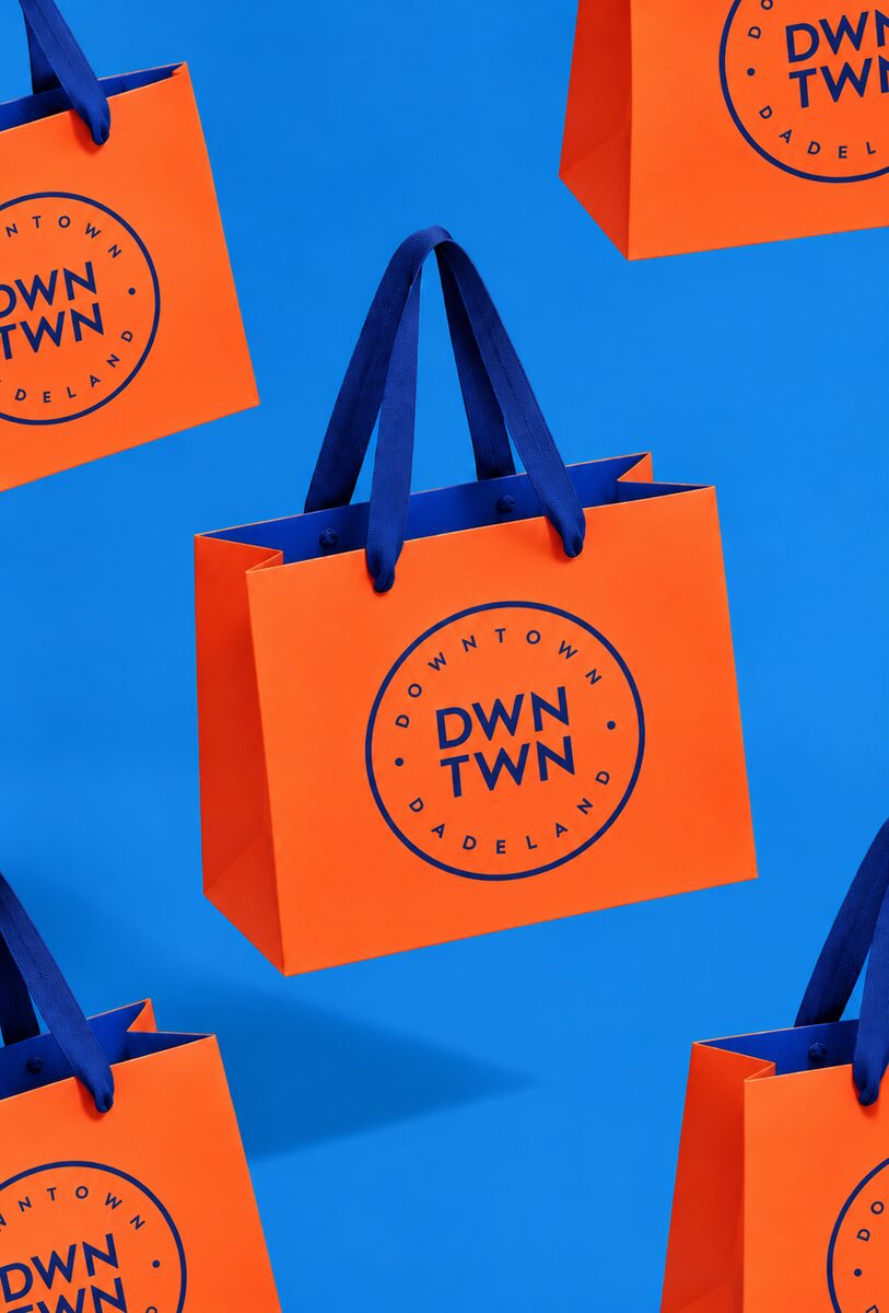 Orange DWNTWN shopping bags with blue handles on blue