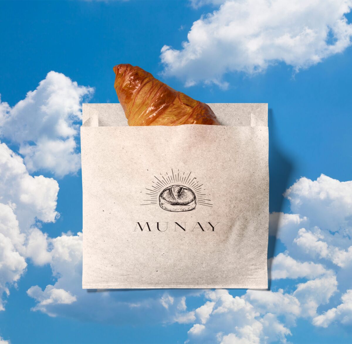 Munay paper bag with a croissant against blue sky